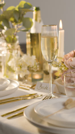 Vertical-Video-Of-Table-Set-For-Meal-At-Wedding-Reception-With-Champagne-And-Place-Card-For-Bride-2